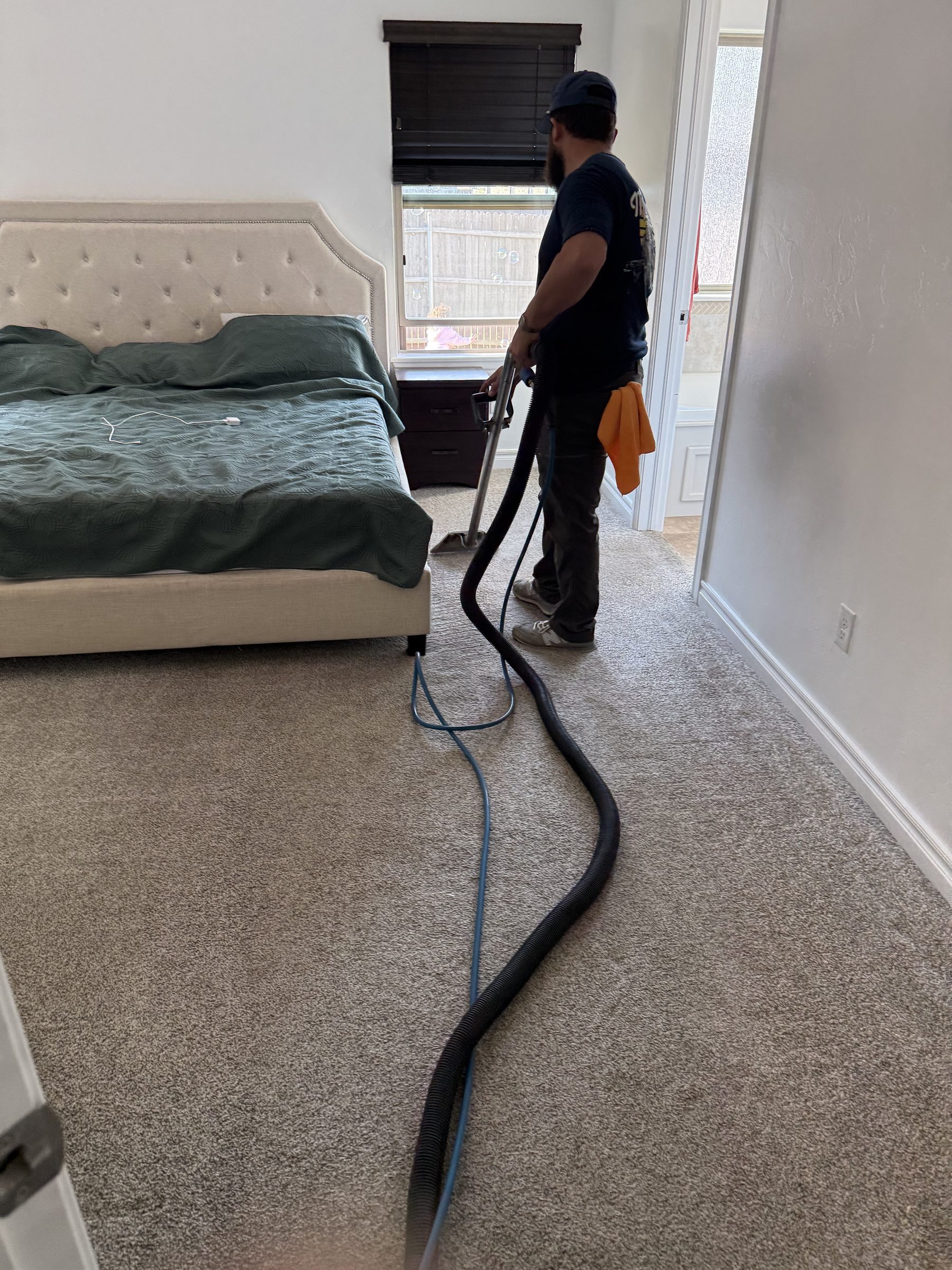 Technician deep cleaning a carpet in a home